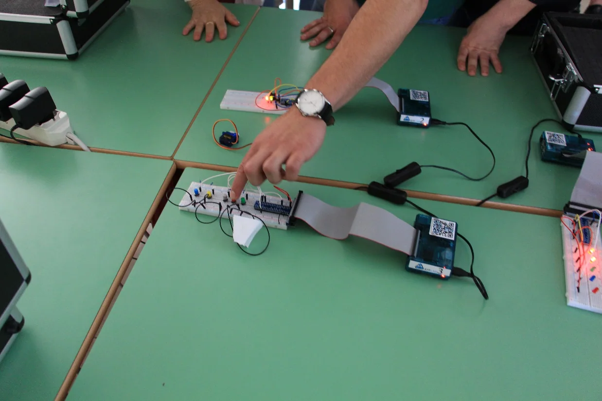 Mani degli studenti durante la verifica di un prototipo IoTLAB su breadboard